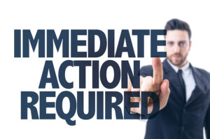 Business man pointing the text: Immediate Action